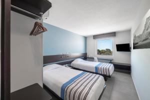 卡门城City Express Junior by Marriott Ciudad del Carmen的酒店客房设有两张床和窗户。