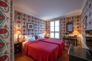 巴黎Hôtel Prince de Conti的一间卧室配有一张带红色床单和壁纸的床