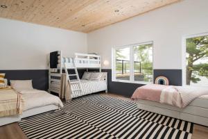 帕里桑德Oastler Lake House的一间卧室配有两张床和条纹地毯。