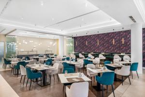 佩奇科索佩斯酒店的餐厅设有白色的桌子和蓝色的椅子