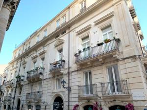 锡拉库扎Appartamenti di Casa VerbaVolant的一座带阳台的大型建筑,种有植物