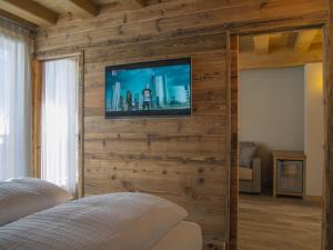 利维尼奥阿美利坚酒店的木墙上设有1间带电视的卧室
