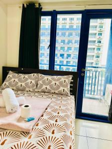 马尼拉Sea Residences by Jan & Val Alano的一张位于带大窗户的房间内的床铺