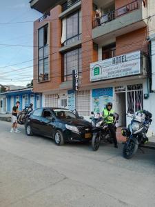 莫科阿Confort Putumayo的站在汽车和摩托车旁的警察