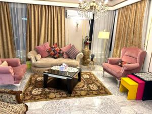 开罗Luxury Apartment 2 Nasr City- City stars的客厅配有粉色家具和吊灯。