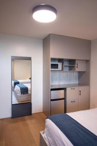 巴拿马城ESHEL SUITES PANAMA的一间小卧室,配有一张床和镜子