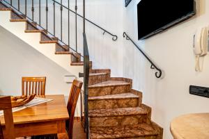 梅佐隆巴尔多Emma Home的客厅设有楼梯、桌子和电视