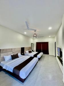 乌贾因Tekri Farms and Retreat的一间卧室配有两张床和电视。