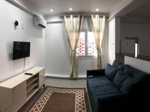 弗洛里亚诺波利斯Apartamento perfeito, faixa mar!的客厅配有蓝色的沙发和电视