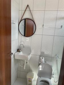 卡鲁阿鲁Pousada Sumaré的一间带水槽、卫生间和镜子的浴室