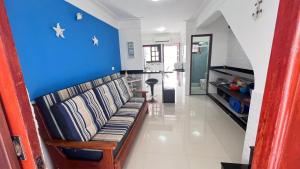 乌巴图巴Condominio Village Americana的带沙发和蓝色墙壁的客厅