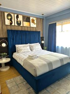 哈博罗内Exquisite short and long stay的卧室内的蓝色床,卧室内有蓝色的墙壁