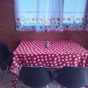 卡奇Cabaña Cachi的红色和白色的桌子,配有椅子和窗帘