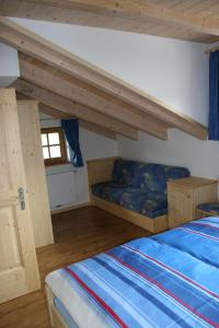 圣坎迪朵Valtnerhof的一间卧室配有一张床和一个沙发