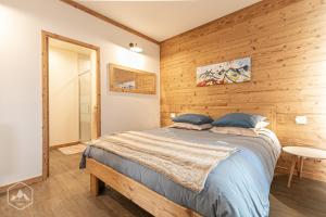 Villarodin-BourgetCôté-Bourget, 2 apparts 10 personnes et 4 personnes, proche des stations La Norma Aussois的一间卧室设有一张床和木墙