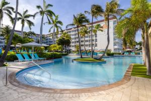 棕榈滩万豪阿鲁巴海洋俱乐部度假村的一座棕榈树游泳池和一座建筑