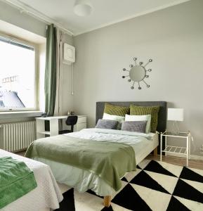 赫尔辛基Chic Urban Oasis at Helsinki Activity Center的卧室配有一张床,墙上挂着一个太阳钟