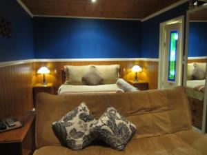 Howqua柳湖别墅酒店的客厅配有沙发和1张床