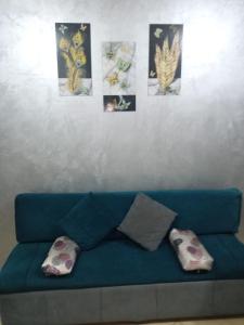 赫尔格达كمبوند سيبريا的一张带枕头的蓝色沙发,墙上挂着图片