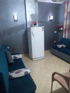 赫尔格达كمبوند سيبريا的客厅配有2张蓝色沙发和冰箱