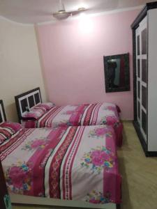 赫尔格达كمبوند سيبريا的卧室设有两张粉红色的床铺。