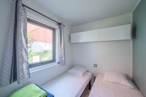 萨维尔纳Camping de Saverne的带窗户的客房内的两张床