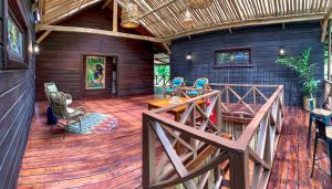 巴斯蒂门多斯The Lodge at Punta Rica- Hilltop Eco-Lodge with Views & Pool的房屋内的大型甲板上配有桌椅