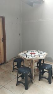 维索萨-杜塞阿拉Sua casa completa em Viçosa do Ceará的一张桌子和四把凳子在房间里