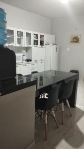 维索萨-杜塞阿拉Sua casa completa em Viçosa do Ceará的厨房配有桌椅和冰箱。