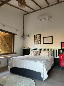 普拉杜Casa Chão的一间卧室配有一张大床和一张红色椅子