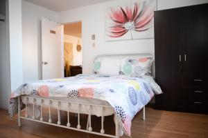 鲁安Logis du Bonheur的卧室配有一张墙壁上粉红色花卉的床。