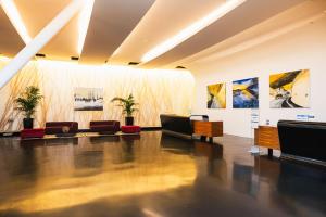 Ferno喜来登米兰马尔彭萨机场酒店及会议中心的客厅配有沙发,墙上挂有绘画作品