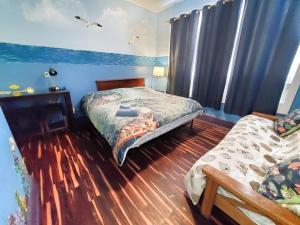 圣奥古斯丁海盗豪斯住宿加早餐旅馆的一间设有两张床的卧室,位于蓝色墙壁的房间