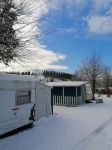 布劳恩拉格Campingplatz Am Bärenbache的停在房子前雪中的 ⁇ 