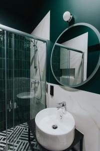 罗兹Apartamenty BIBLIO的一间带水槽、淋浴和镜子的浴室