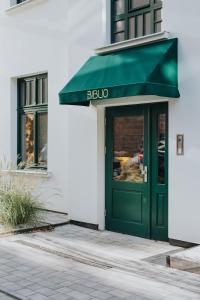 罗兹Apartamenty BIBLIO的绿色的大门,带有绿色遮阳篷的商店