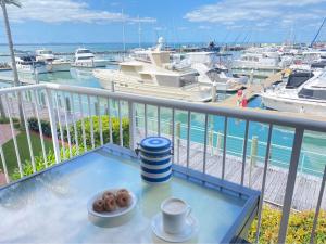 UranganMarinaView Unit 24 - Break Free Resort- 2 Bedroom Self Contained的阳台上的桌子上放着咖啡和甜甜圈