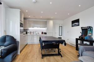 伦敦Greenwich O2 Apartment的一间带乒乓球桌的客厅和一间厨房