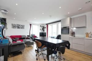 伦敦Greenwich O2 Apartment的厨房以及带桌椅的起居室。