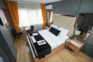 伊斯坦布尔Lukka Suit Hotel的卧室配有一张白色的大床和一张桌子