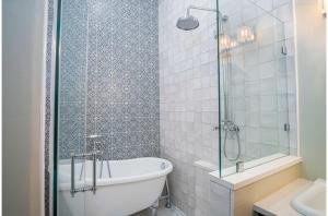 圣安东尼奥Exquisite Studio Guesthouse Near Downtowns Core的带浴缸和玻璃淋浴间的浴室。