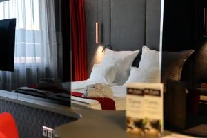 布拉戈耶夫格勒Spa Hotel Ezeretz Blagoevgrad的一间卧室配有带白色床单和枕头的床。