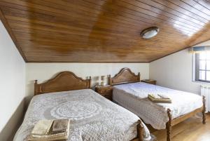 萨布盖鲁Casa do Patrão - Quartos的卧室设有两张床铺和木制天花板