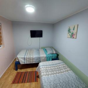 拉塞雷纳Hospedaje Walgün的一间卧室配有两张床和一台平面电视