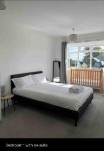 FeltonGreen 3 bed bungalow with en-suite and parking的一间卧室配有一张带c沙发和窗户的床。