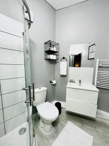 Walton on the HillKos apartament 1的浴室配有卫生间、盥洗盆和淋浴。