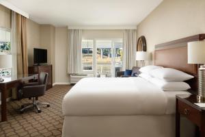 佩塔卢马Sheraton Sonoma Wine Country Petaluma的酒店客房设有一张白色大床和一张书桌