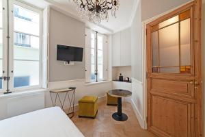 巴黎Pavillon Marais的一间卧室设有一张床、一台电视和一个窗口。