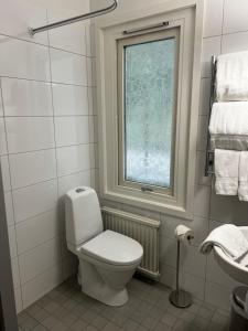 哥德堡Ewa & Maude Hotel Aston Villa的白色的浴室设有卫生间和窗户。