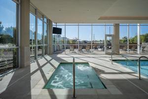 威奇托福尔斯Delta Hotels by Marriott Wichita Falls Convention Center的一座带玻璃窗的建筑中的游泳池